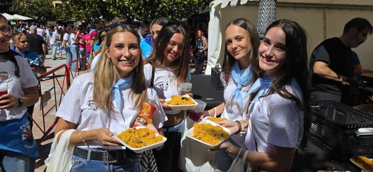 Grupo de jóvenes sosteniendo platos de comida en un evento festivo