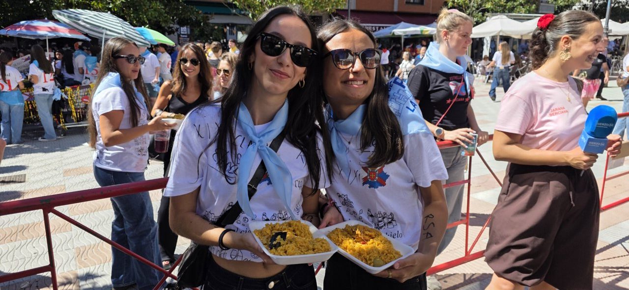Dos mujeres sosteniendo platos de comida en una celebración