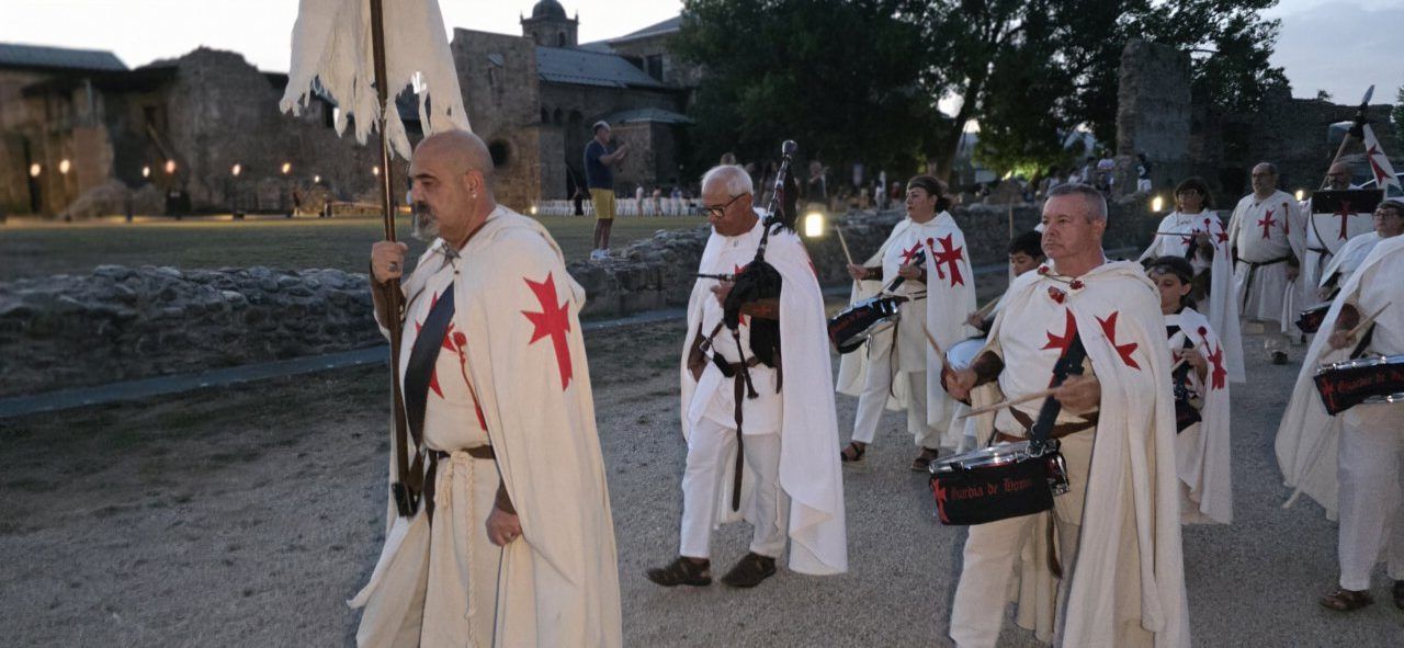 Grupo de personas vestidas con túnicas en un recorrido teatralizado en Carracedo del Monasterio