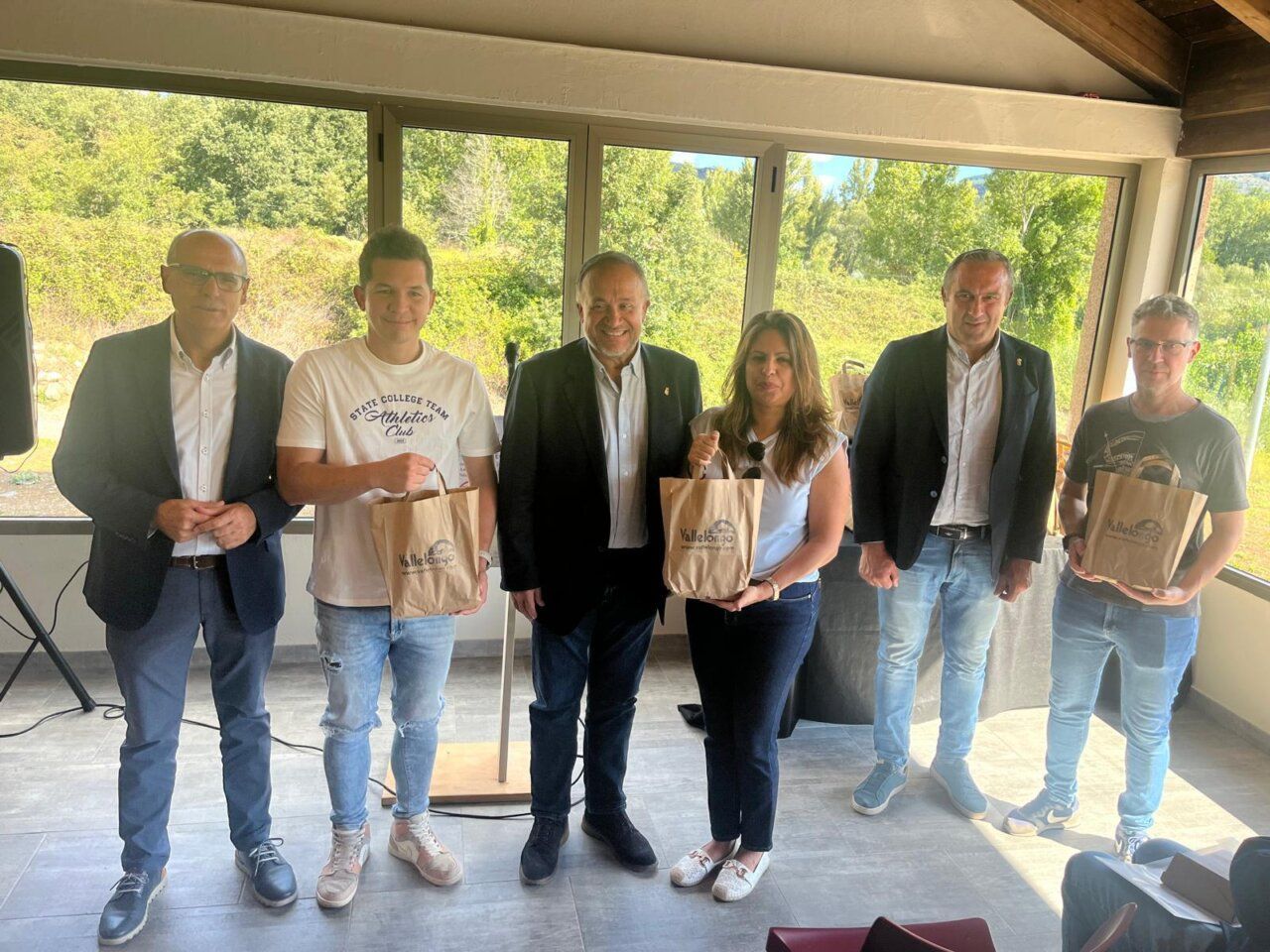 Grupo de personas en un evento en Corullón con bolsas de regalo