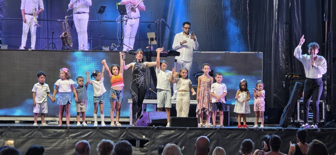 Niños y artistas en el escenario durante la celebración de San Roque en Molinaseca
