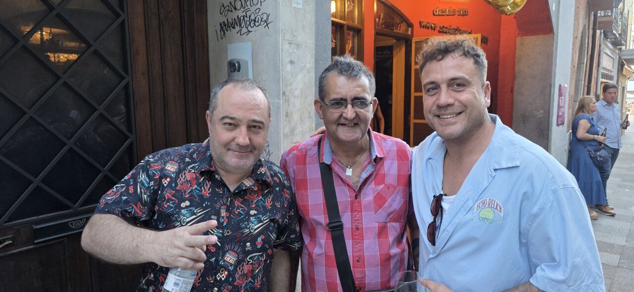 Tres hombres sonrientes en la celebración del aniversario de la Sala Tararí