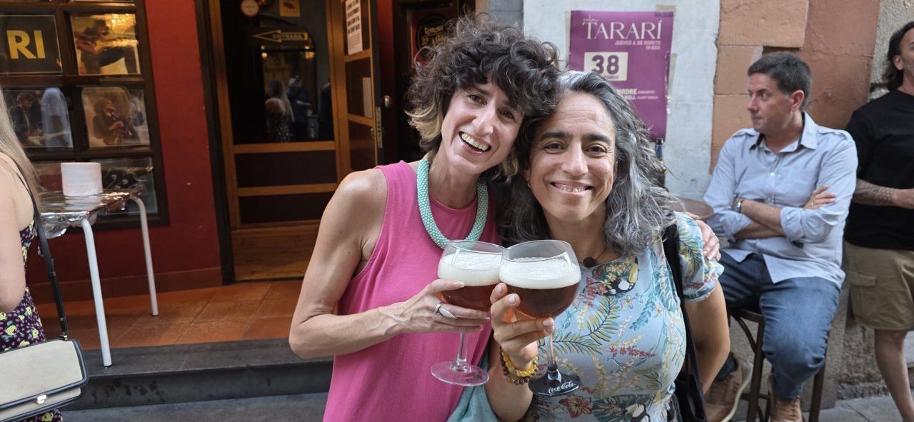 Dos mujeres sonrientes sosteniendo copas en la celebración del aniversario de la Sala Tararí