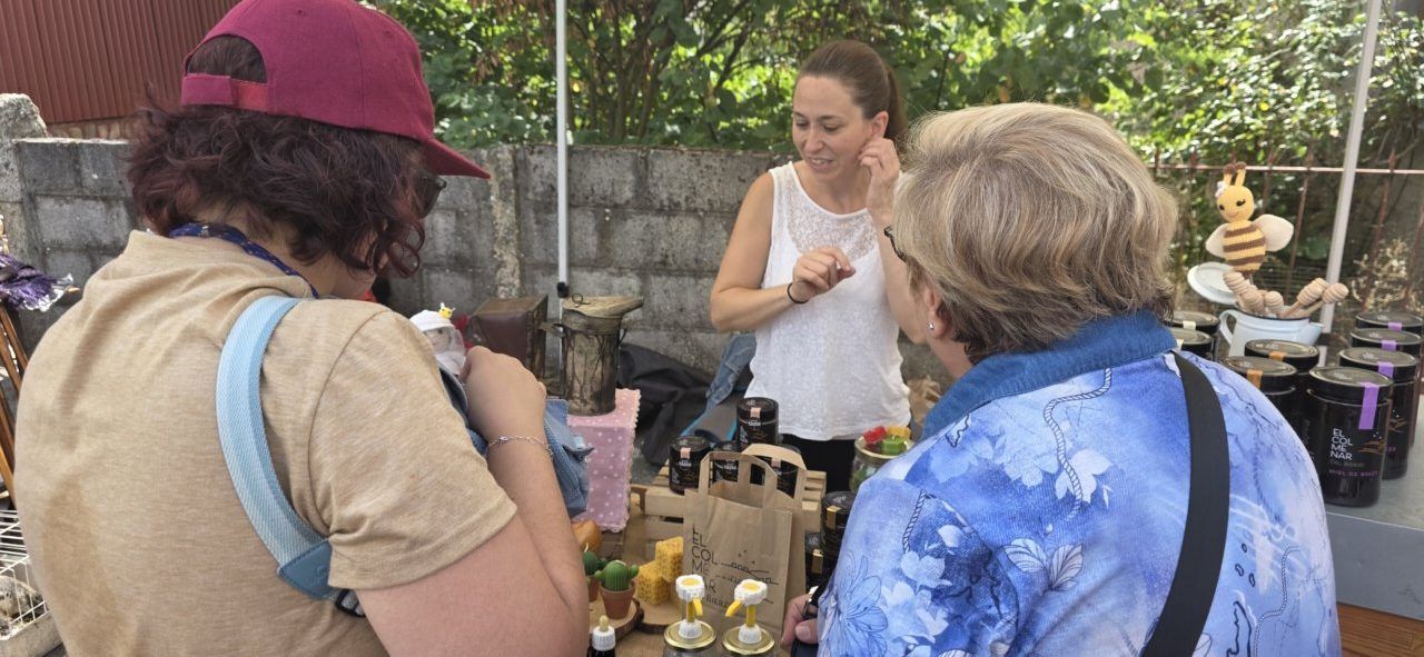 Mujeres interactuando en un puesto de la Feria del Ajo