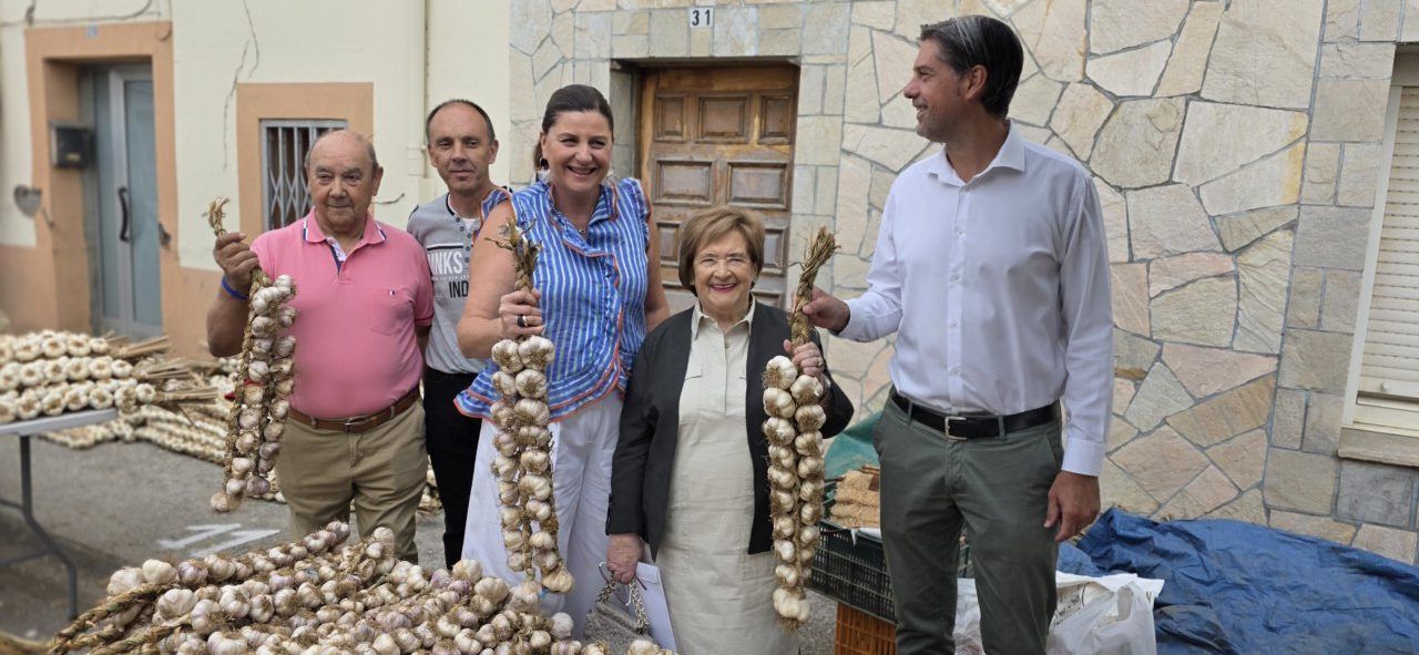 Participantes sosteniendo ajos en la Feria del Ajo de San Miguel de las Dueñas