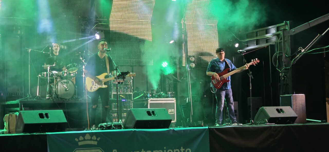 Banda tocando en un concierto con luces verdes en Ponferrada