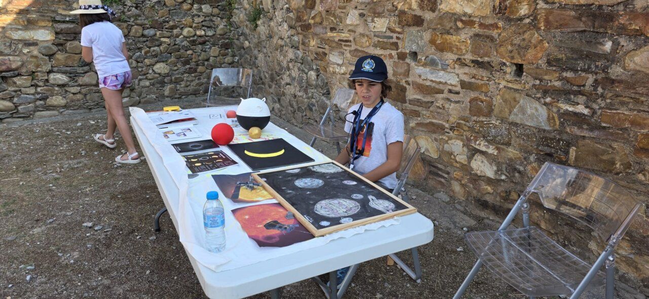 Niño observando materiales sobre el eclipse solar en el castillo