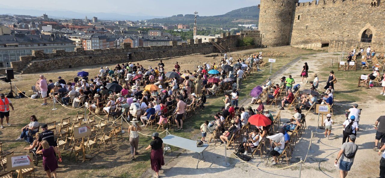 Multitud de personas observando un eclipse solar desde un castillo