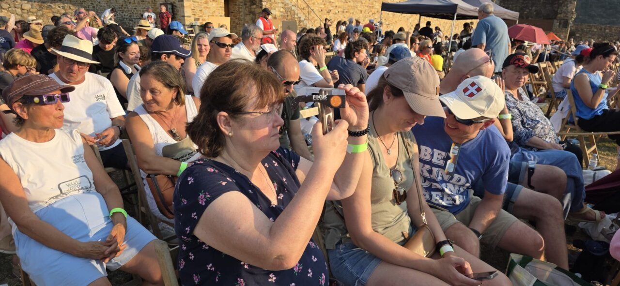 Personas observando un eclipse solar en el Castillo de Ponferrada