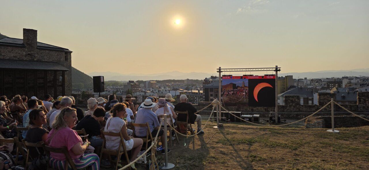 Personas observando un eclipse solar desde el Castillo de Ponferrada