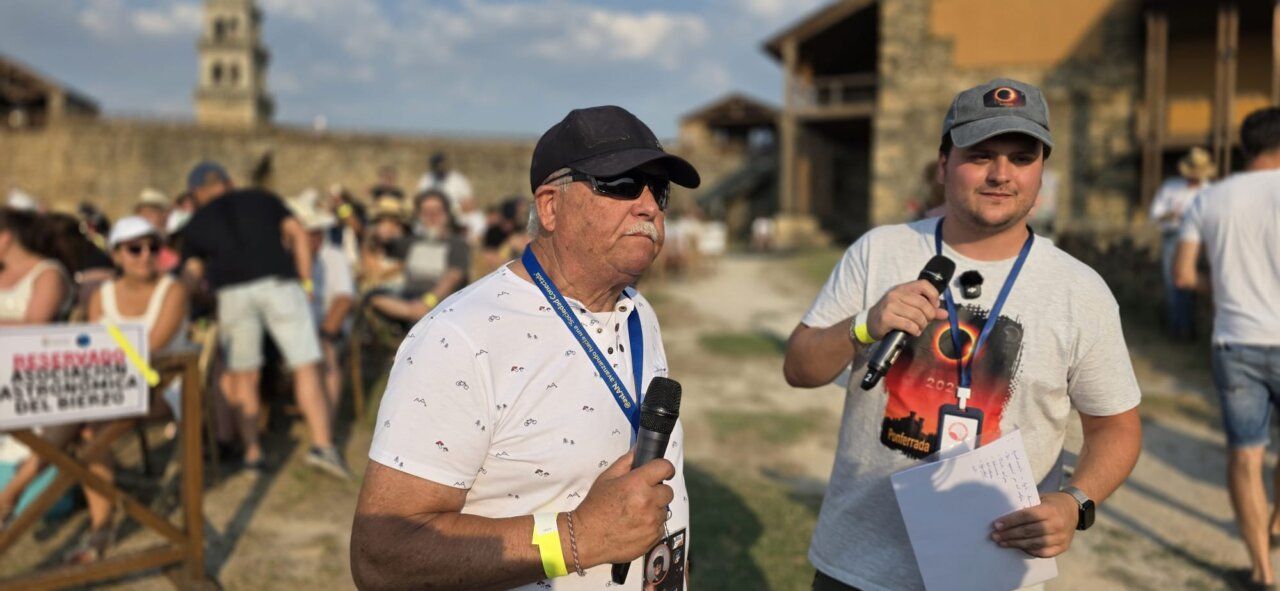 Dos hombres con micrófonos en el Castillo de Ponferrada durante un eclipse solar