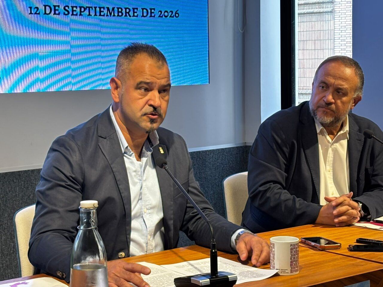 Dos hombres hablando en una conferencia sobre el Gran Concejo en León