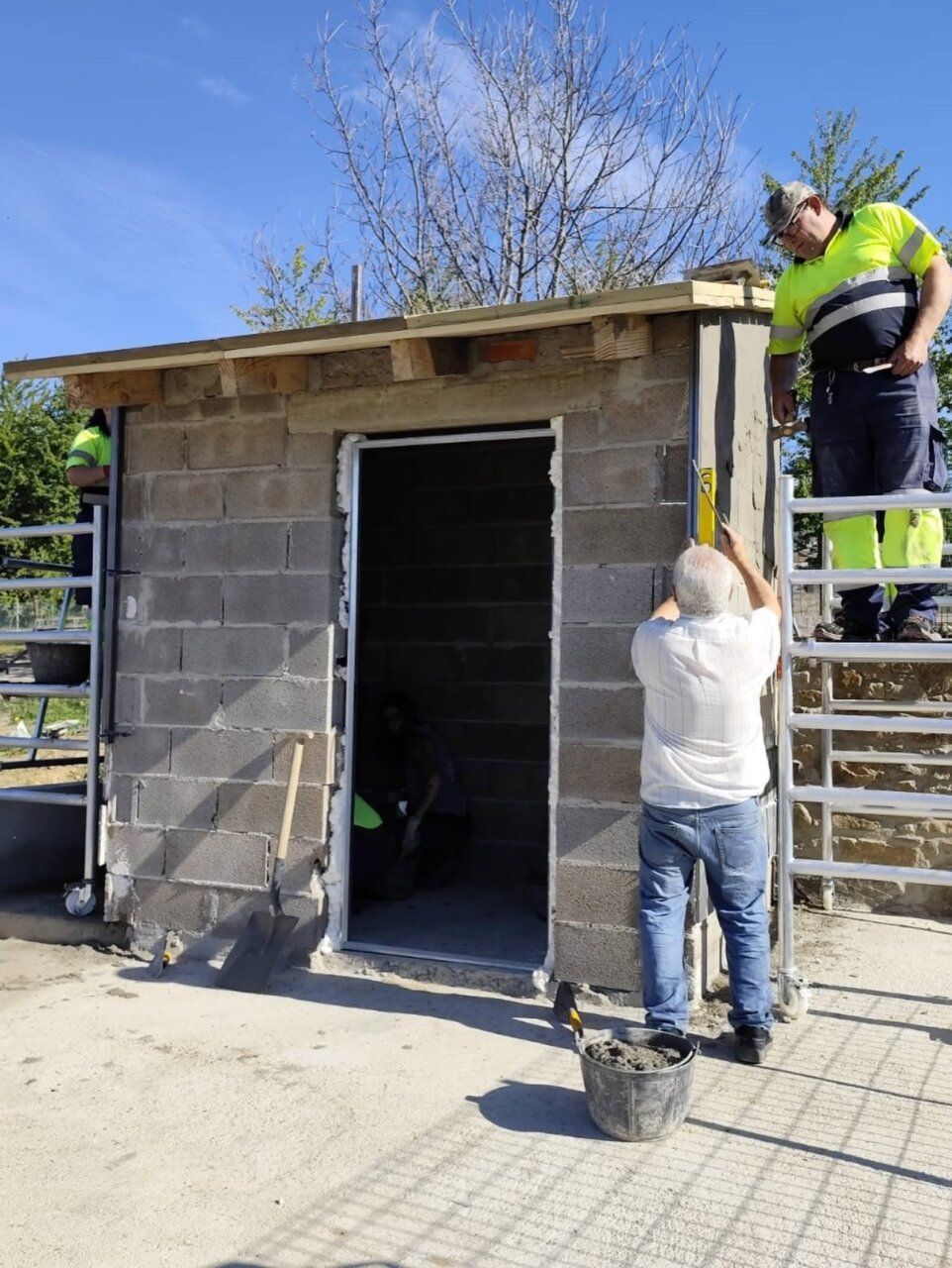 Trabajadores construyendo una caseta de almacenamiento en Fabero
