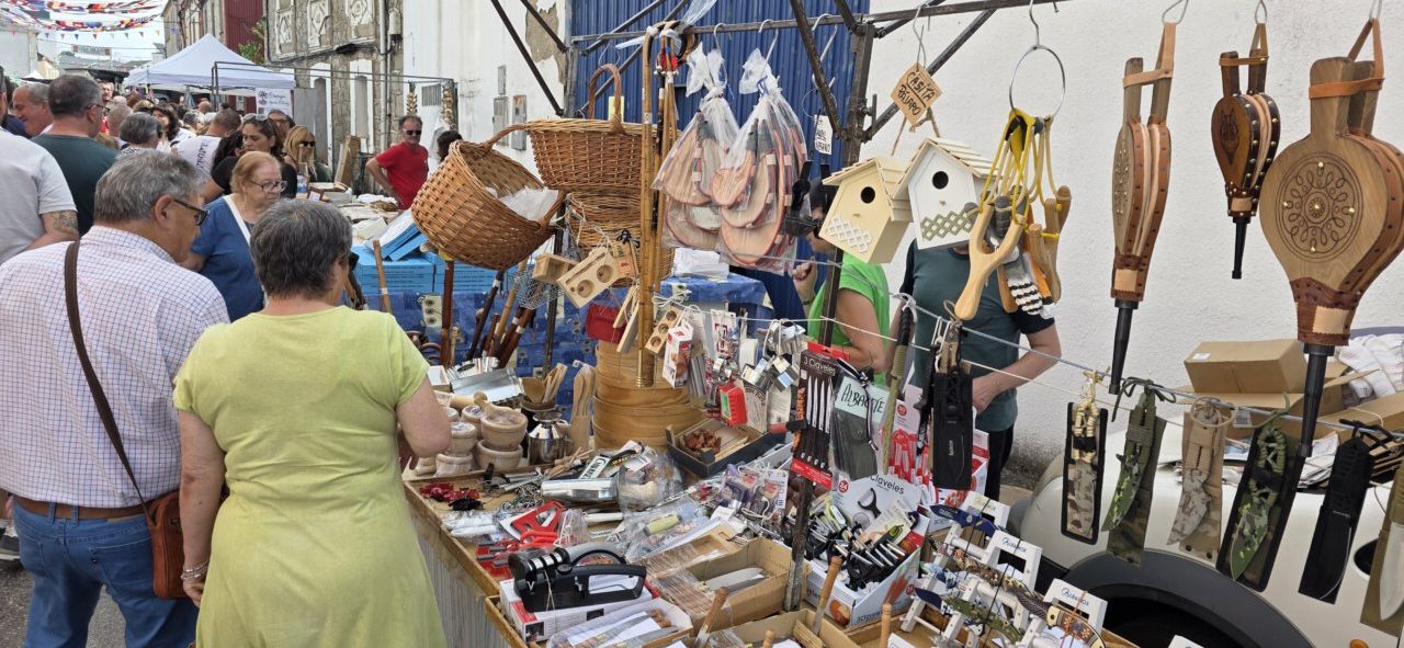 Visitantes en la XXIII Feria del Ajo de San Miguel de las Dueñas observando productos artesanales.