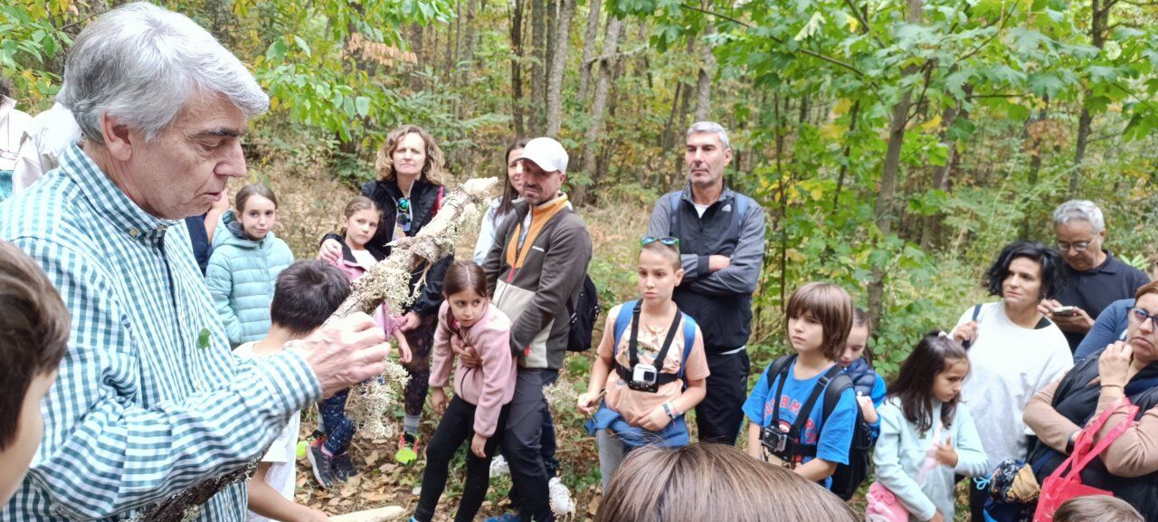 Guía mostrando a un grupo de niños sobre la biodiversidad en el bosque