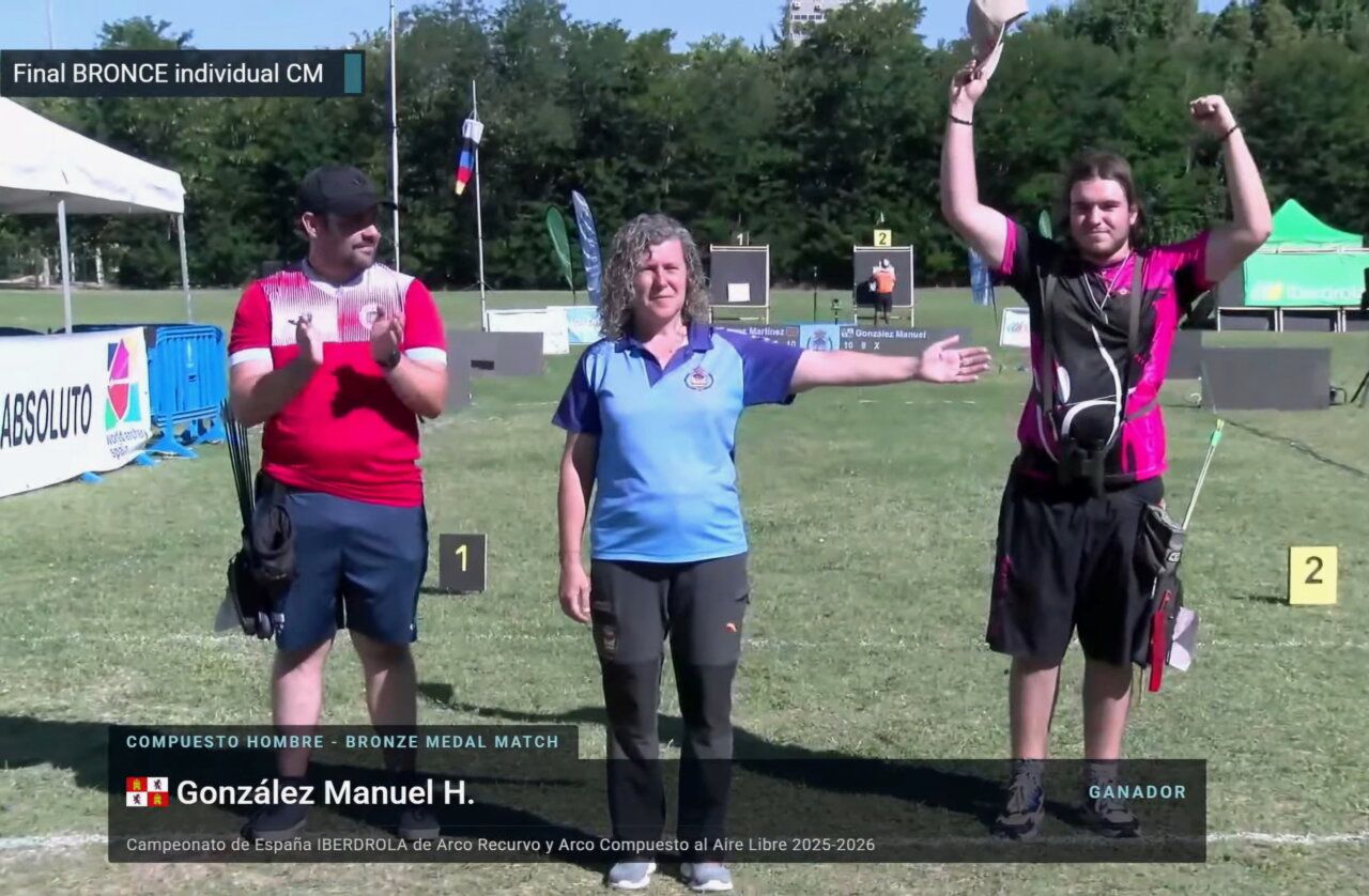 Competidor levantando su sombrero tras ganar medalla de bronce en tiro con arco.