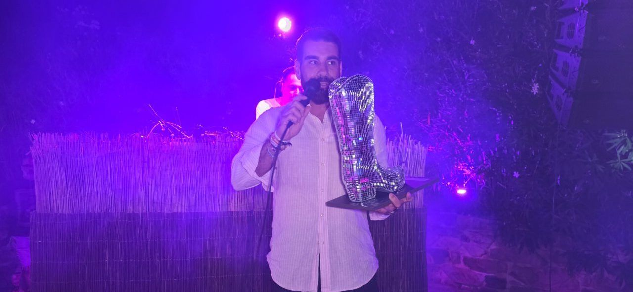 Persona sosteniendo un trofeo en un evento homenaje a Ángela Show