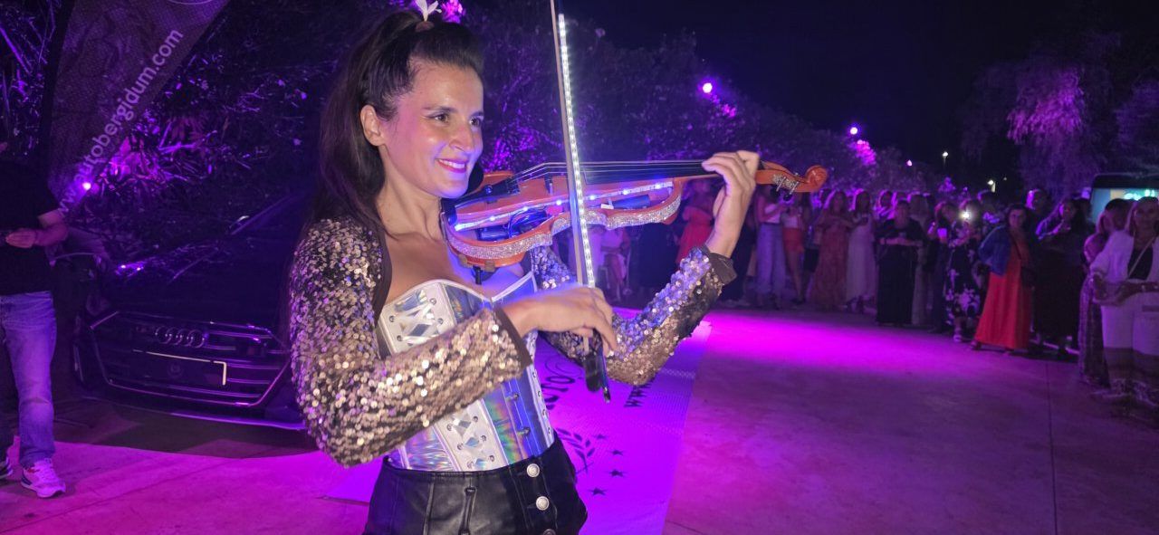 Mujer tocando el violín en un homenaje a Ángela Show