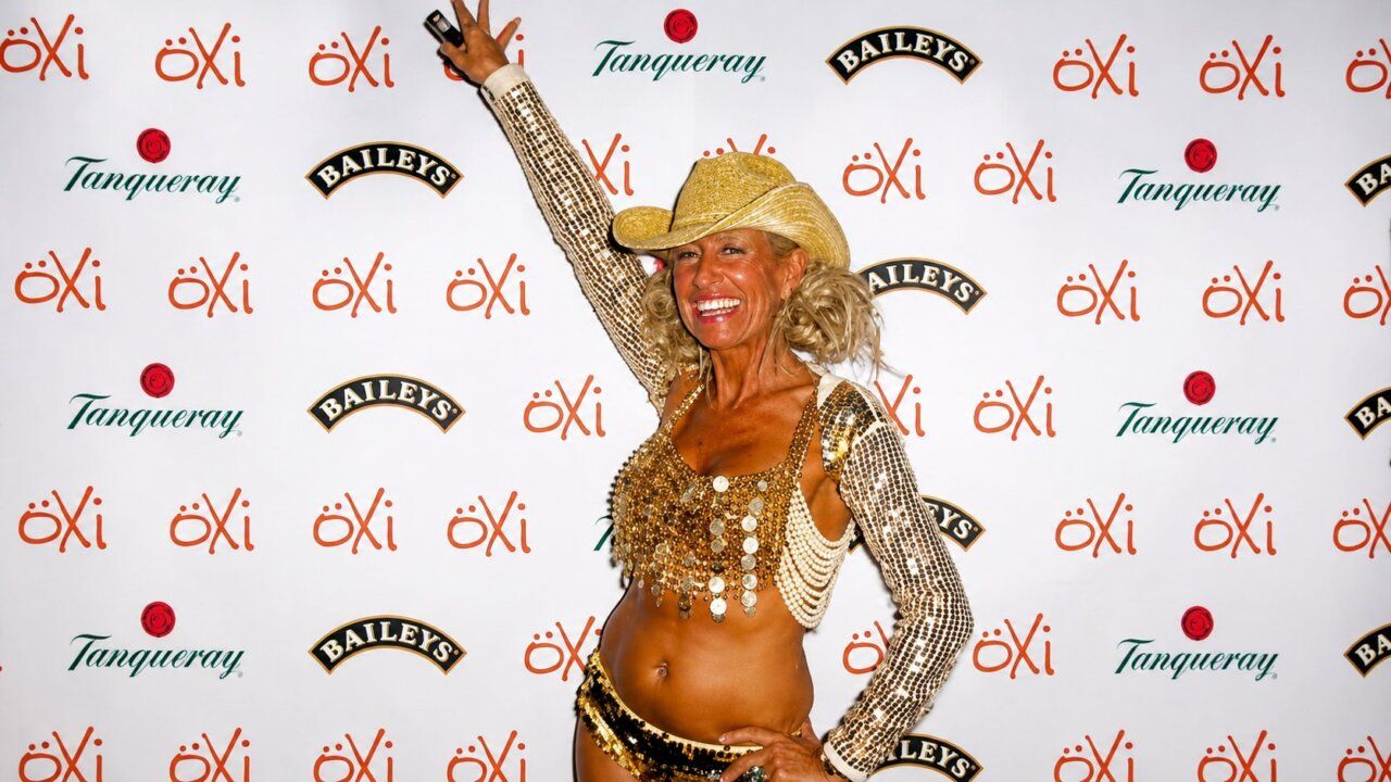 Ángela Show en una fiesta con atuendo brillante y sombrero