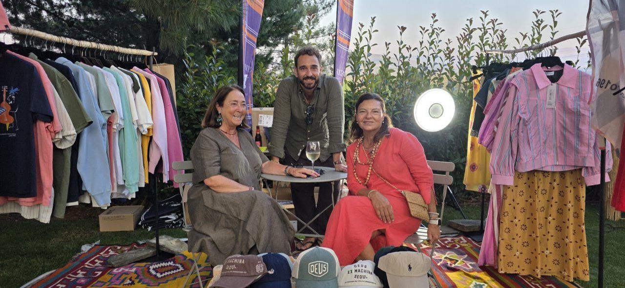 Tres personas posando en un evento con ropa de moda y ambiente festivo