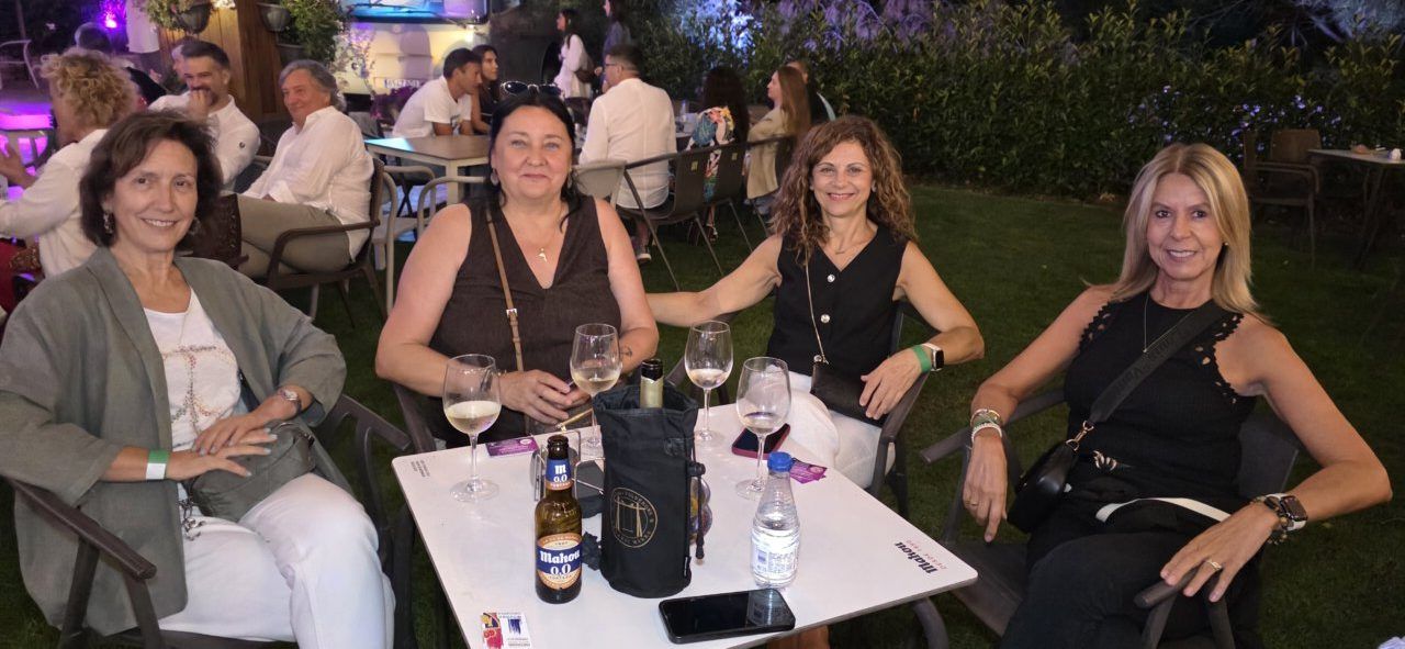 Cuatro mujeres disfrutando en la terraza Malumba durante el concierto de Pavlenha