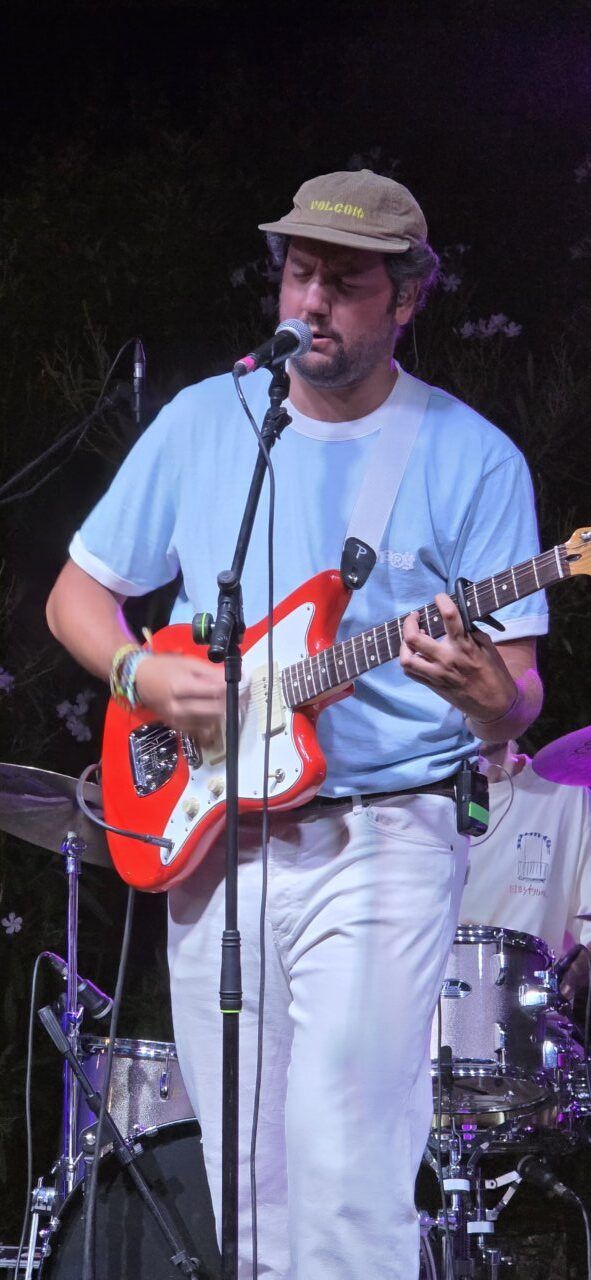 Artista Pavlenha tocando guitarra en concierto en Malumba