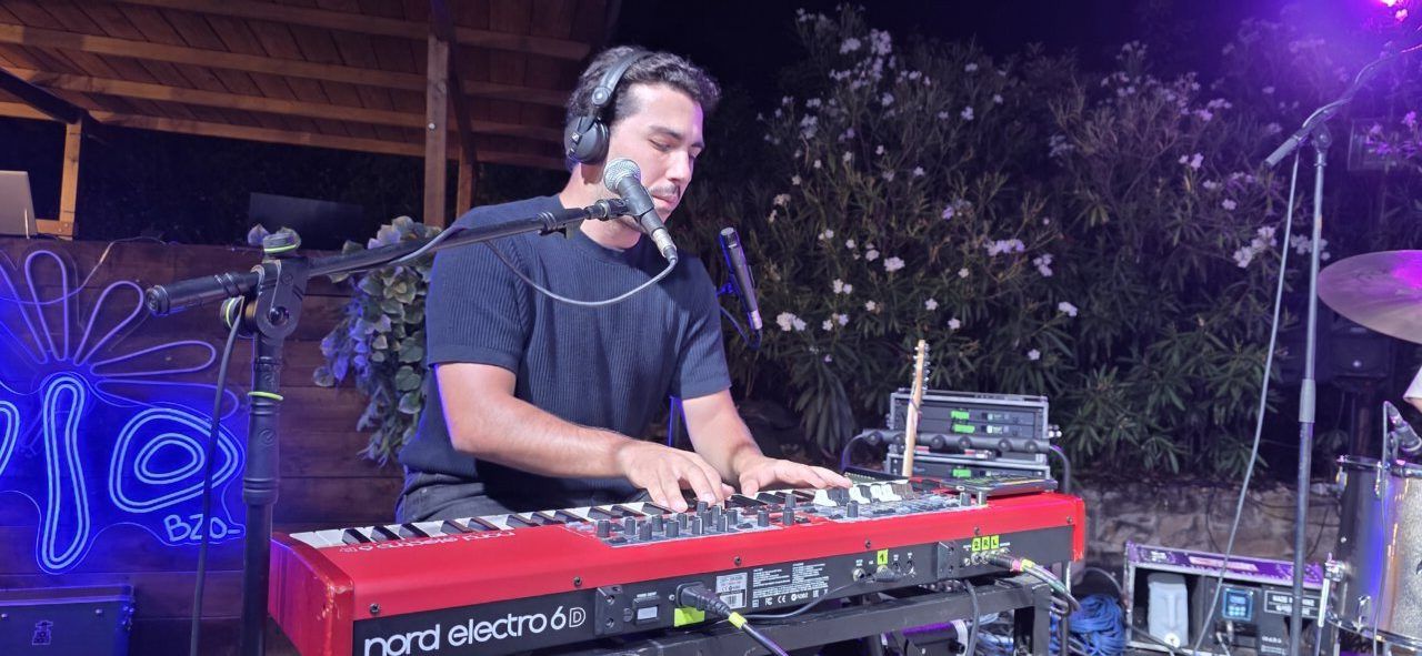 Artista Pavlenha tocando un teclado en un concierto en Malumba