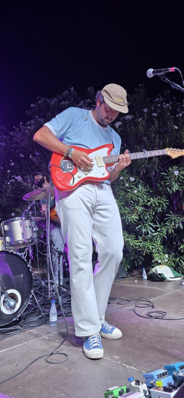 Músico tocando guitarra eléctrica en el concierto de Pavlenha en Malumba