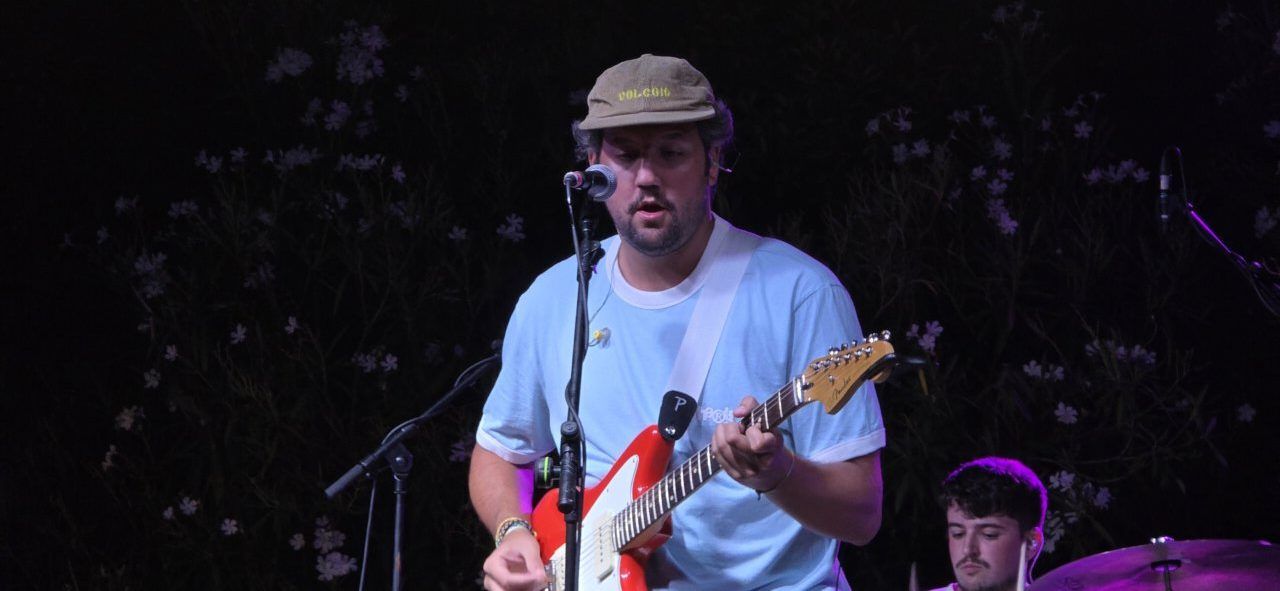 Artista Pavlenha tocando la guitarra en un concierto en Malumba