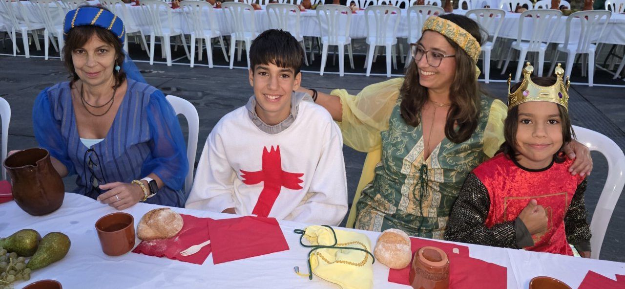 Familia vestida con trajes medievales en una mesa decorada