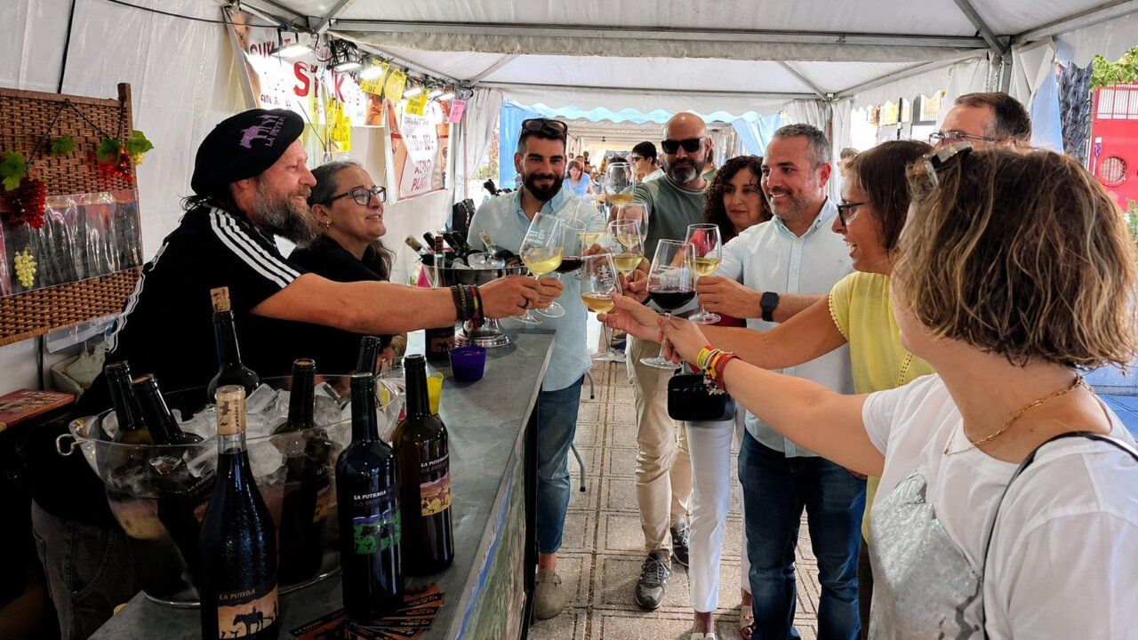 Personas brindando en el Mercado de Verano de Ponferrada con productos locales.