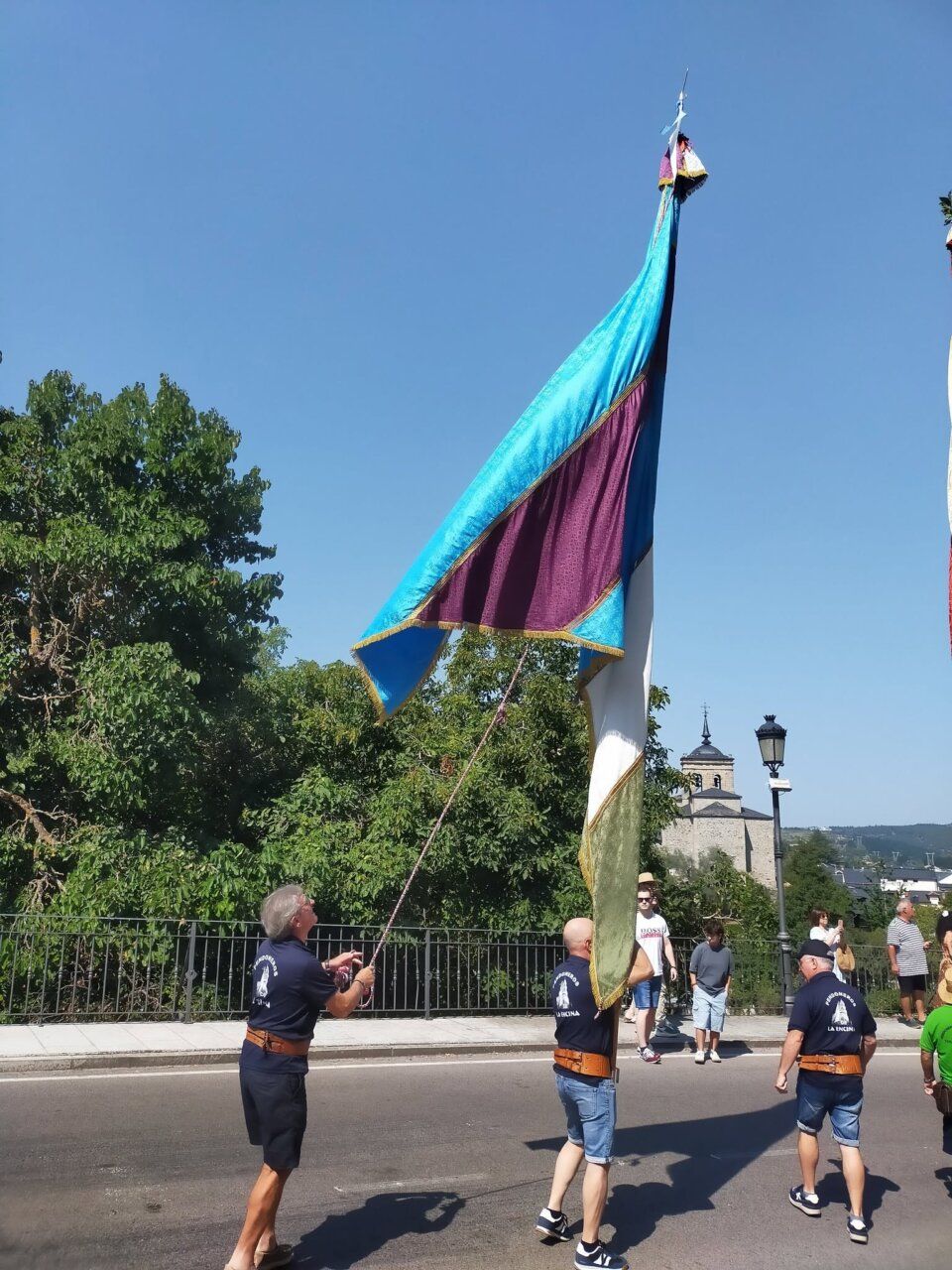 Hombres sosteniendo una bandera durante la procesión en Molinaseca