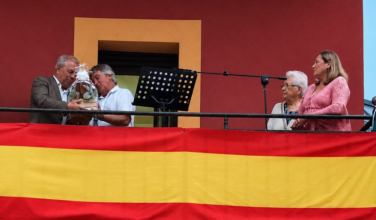 Dos hombres intercambiando un regalo en el pregón de San Roque en Torre del Bierzo