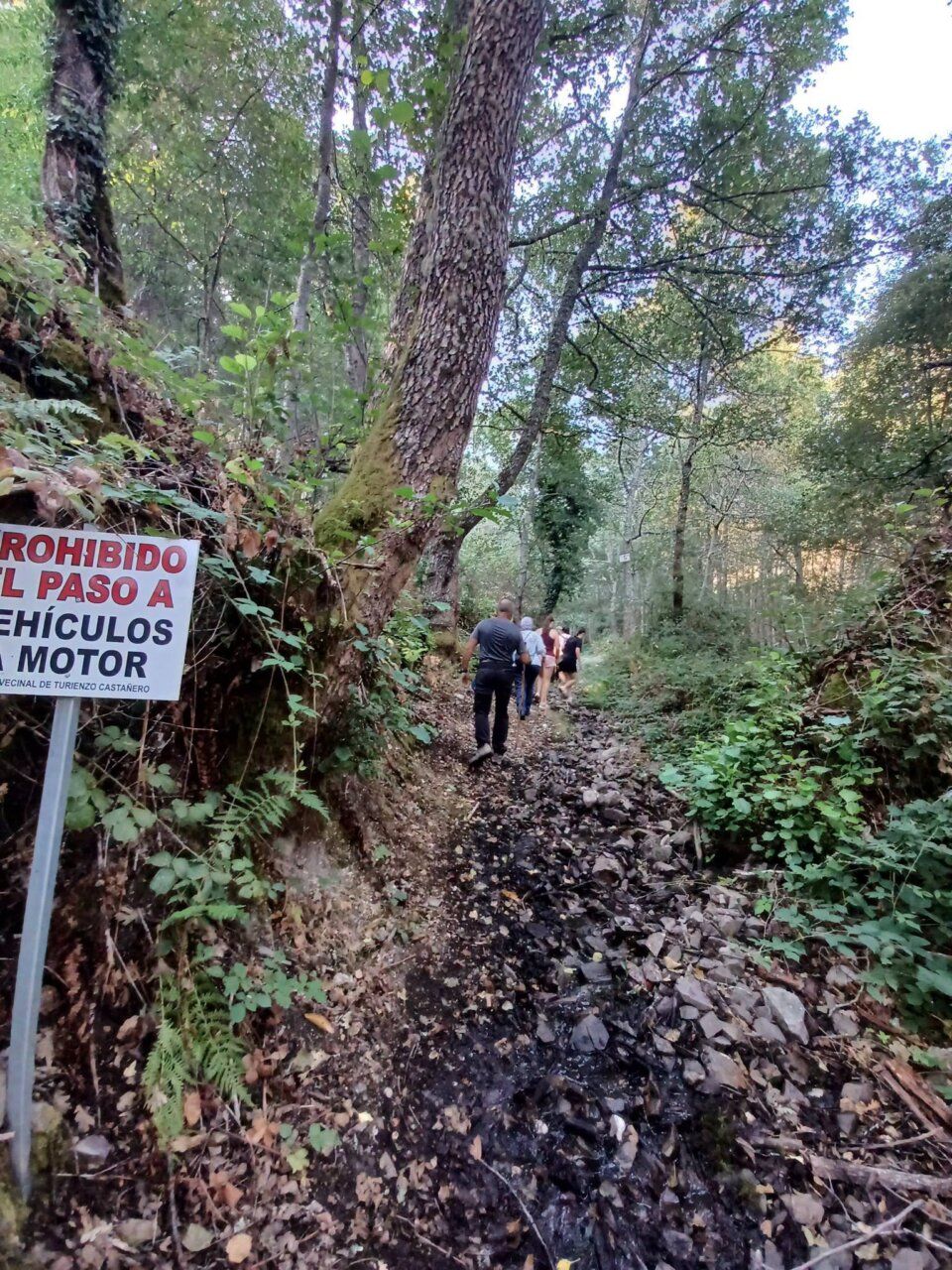 Grupo de personas caminando por un sendero hacia la Fuente de la Risa