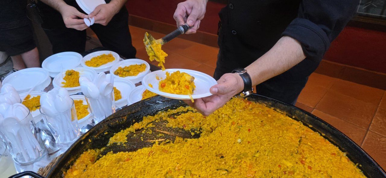 Persona sirviendo paella en la celebración del aniversario de la Sala Tararí