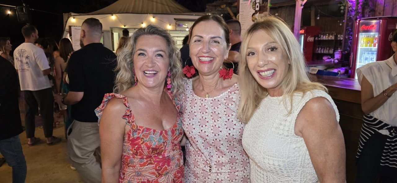 Tres mujeres sonriendo en la Terraza Malumba durante un homenaje