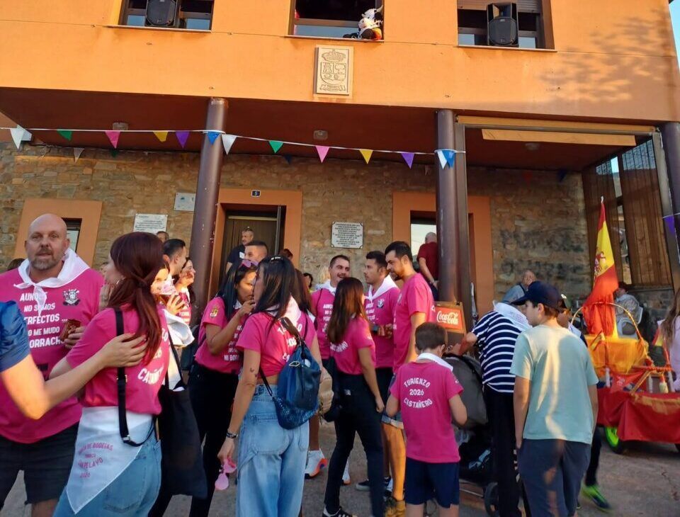 Grupo de personas en evento festivo frente a edificio en Turienzo-Castanero