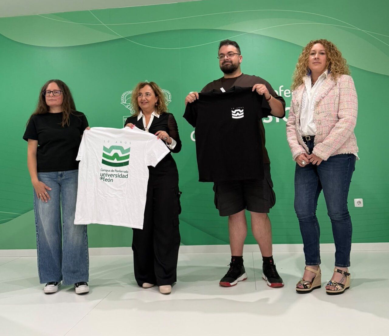 Cuatro personas sosteniendo camisetas del Campus de Ponferrada