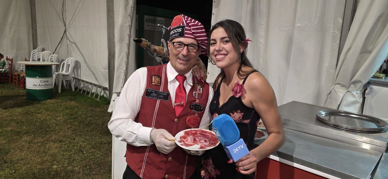 Persona con plato de jamón y mujer en la Casa de Andalucía