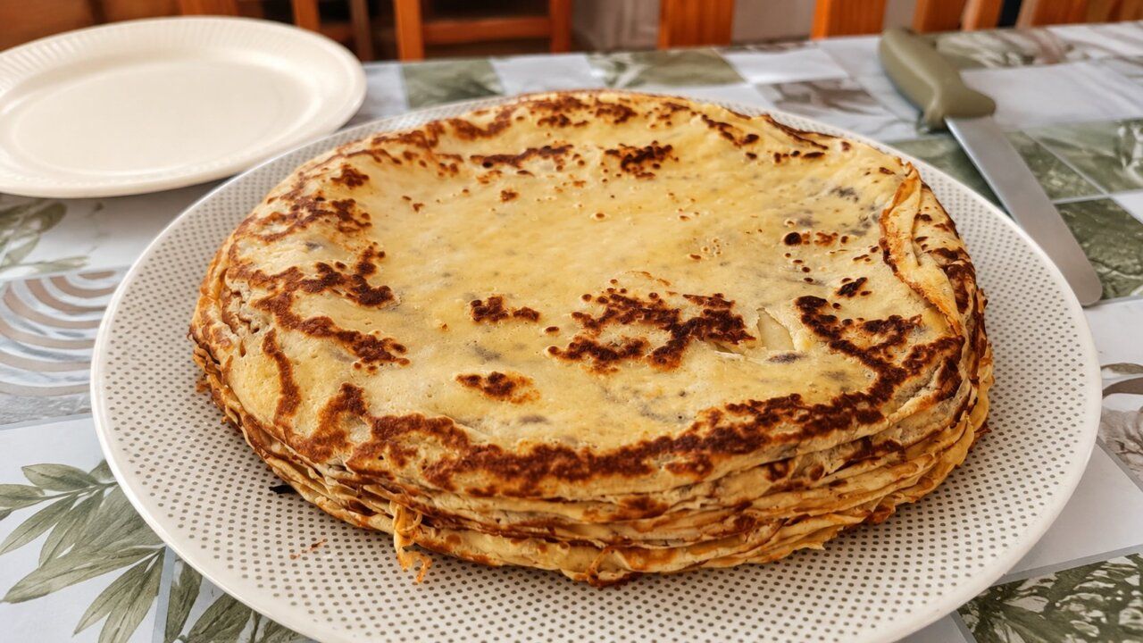 Tortilla apilada en un plato sobre una mesa decorada