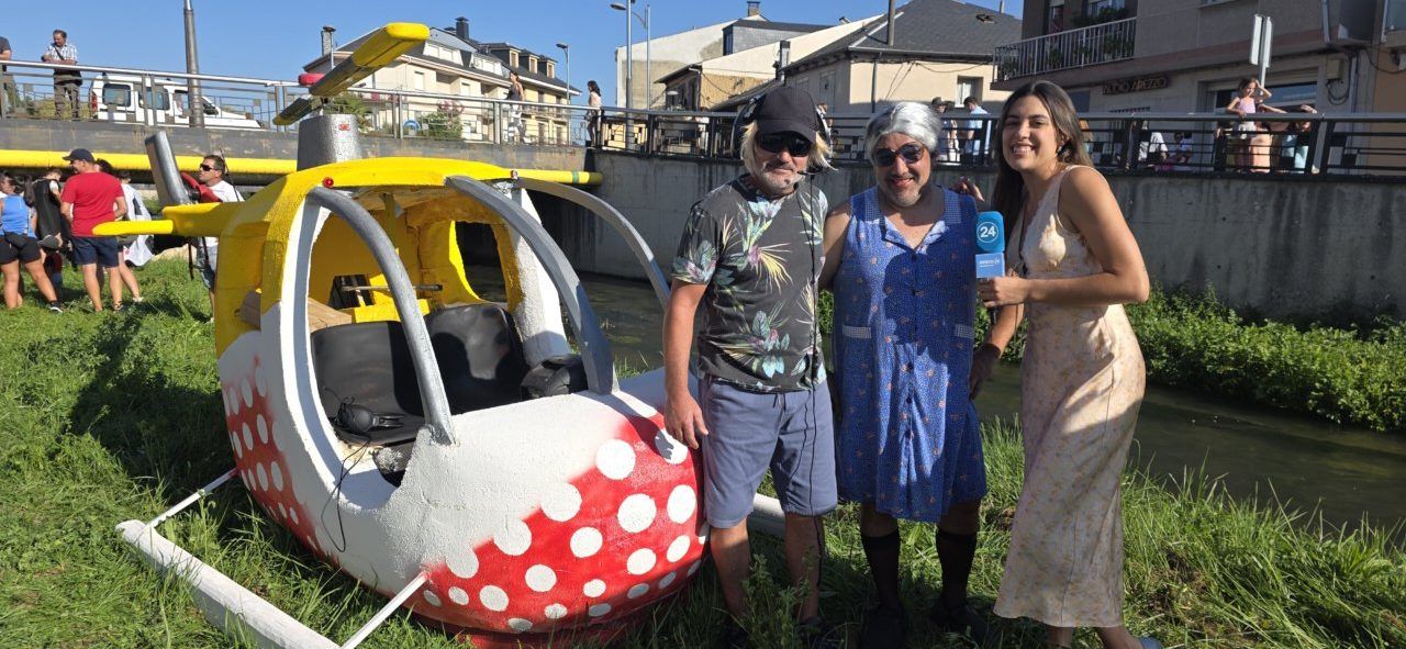 Participantes del Descenso del Naraya en Camponaraya junto a un helicóptero decorativo.