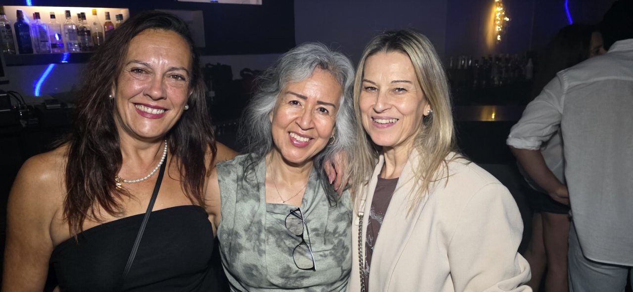 Tres mujeres sonrientes en la fiesta de los 80 y 90 en Ponferrada