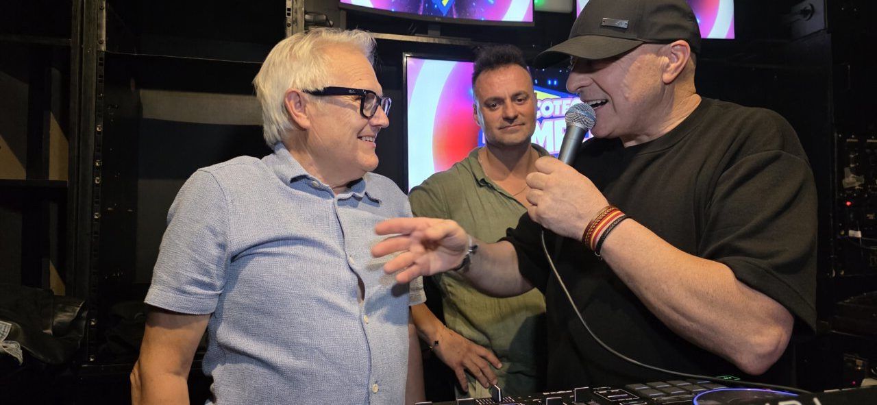 Tres hombres conversando en la fiesta de los 80 y 90 en Ponferrada