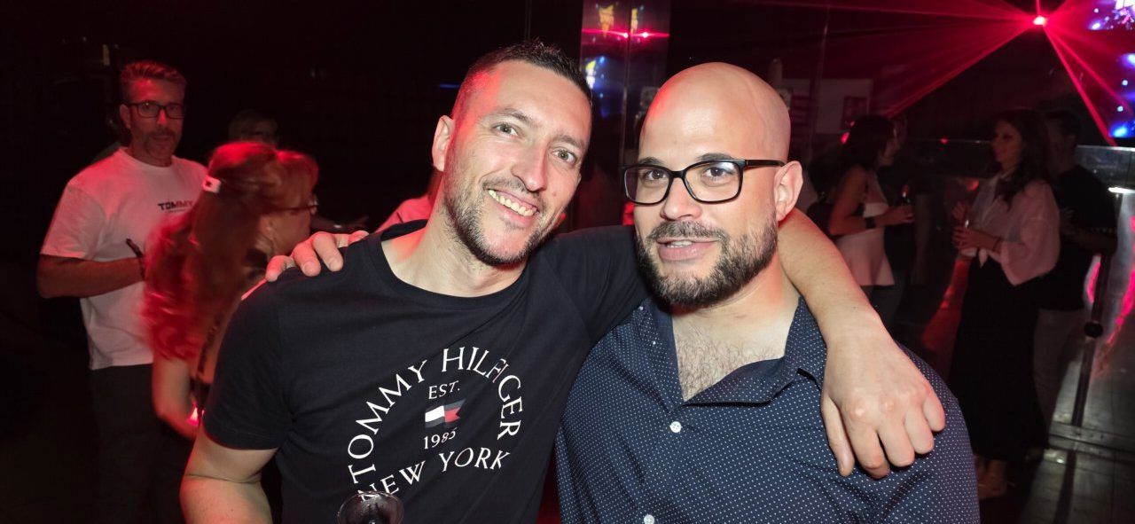 Dos hombres sonriendo en la fiesta de los 80 y 90 en Ponferrada
