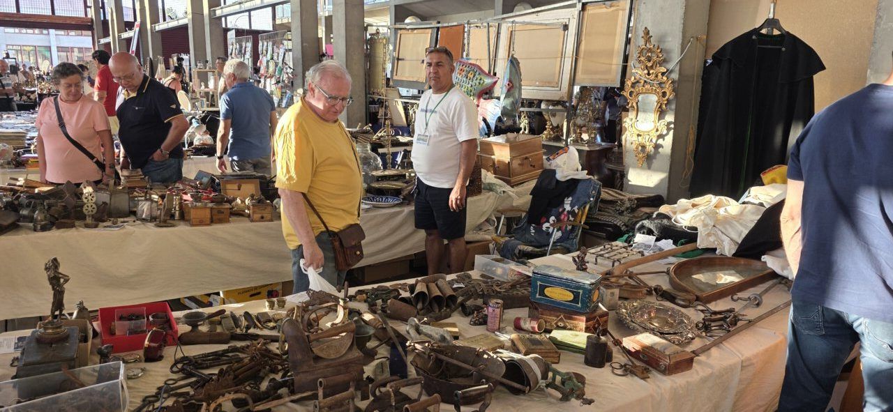 Visitantes explorando puestos en la feria de antigüedades en Ponferrada