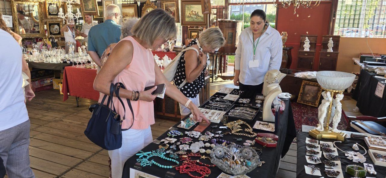 Visitantes explorando puestos en la II Feria de Antigüedades en Ponferrada