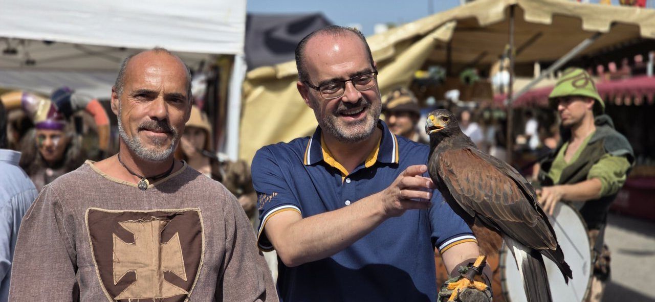 Personas en el Mercado Medieval de Ponferrada con un ave rapaz