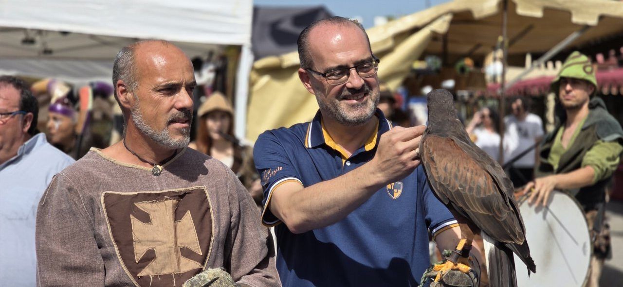 Personas en el Mercado Medieval de Ponferrada con un ave rapaz
