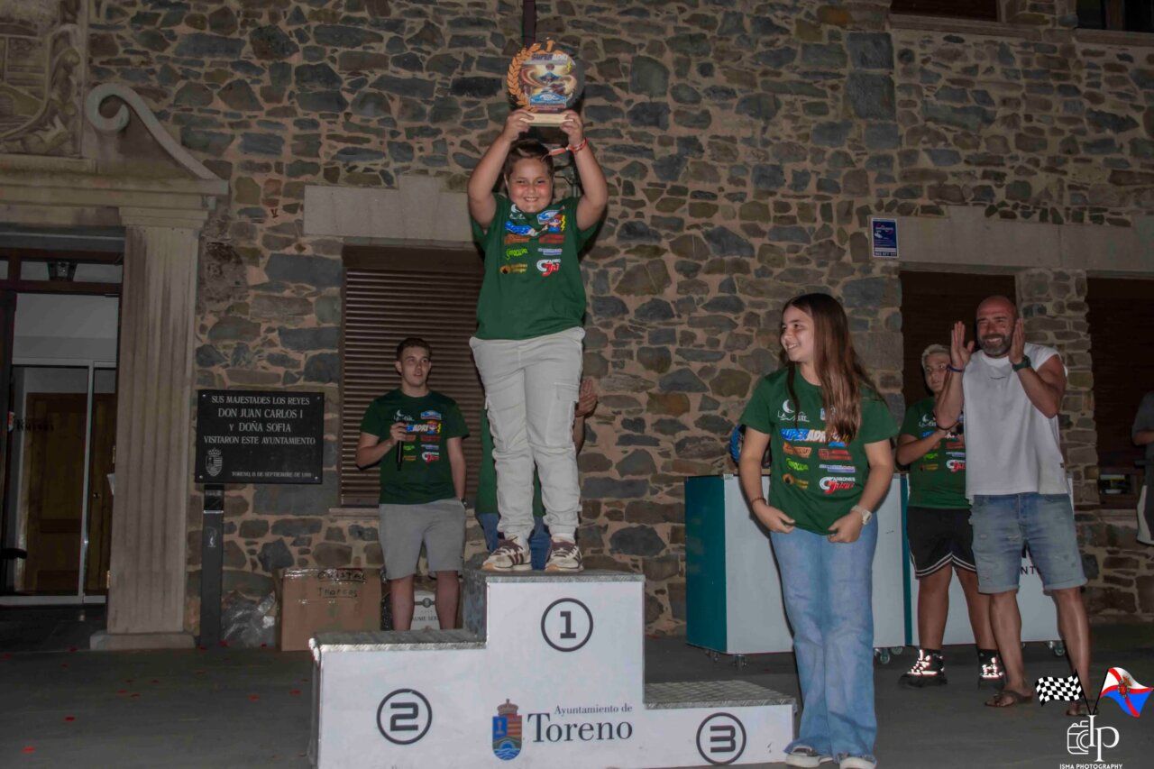 Niña levantando un trofeo en el podio del Rallysprint Villa de Toreno