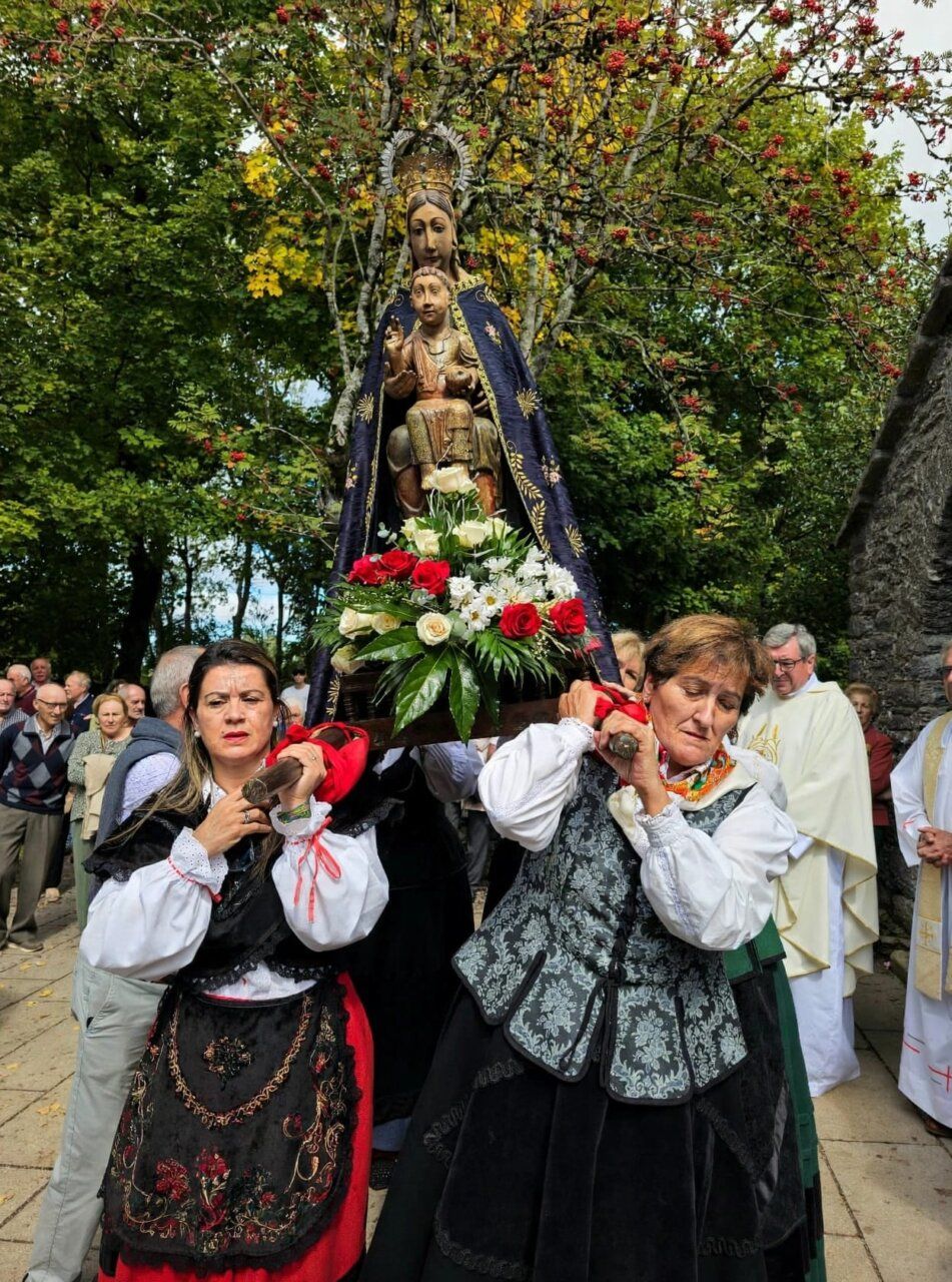 Dos mujeres cargando una imagen de la Virgen durante la procesión del Santo Milagre.